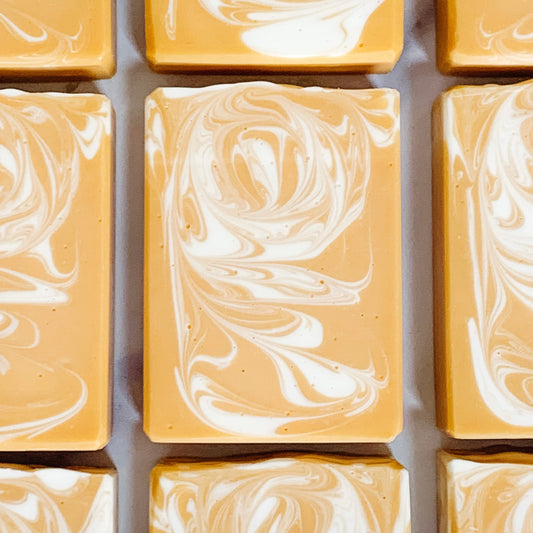 A grid of handmade banana coconut artisan soap bars with a marbled yellow and white pattern, arranged to form a larger image.