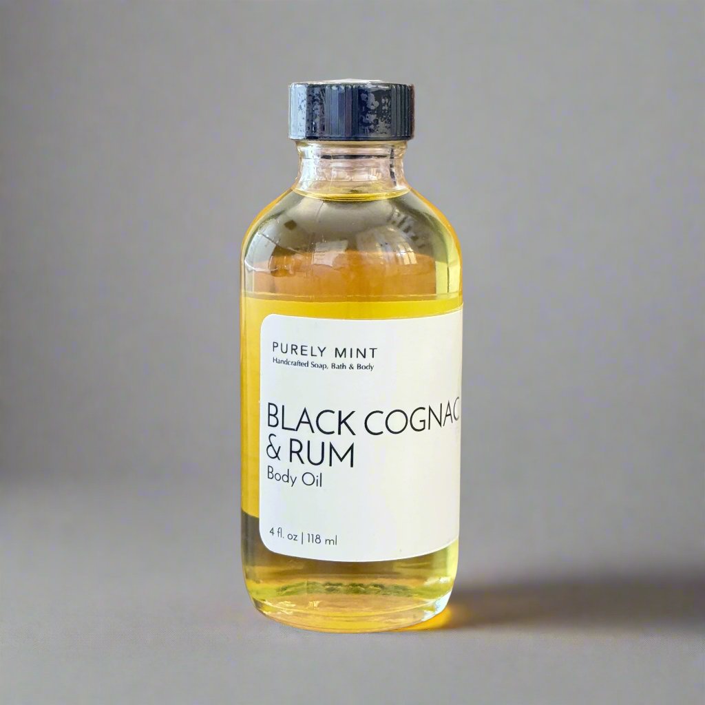 Black Cognac & Rum 4 oz body oil in clear class bottle white label bllack top. Commercial photography packshot, light gray seamless backdrop, neutral lighting