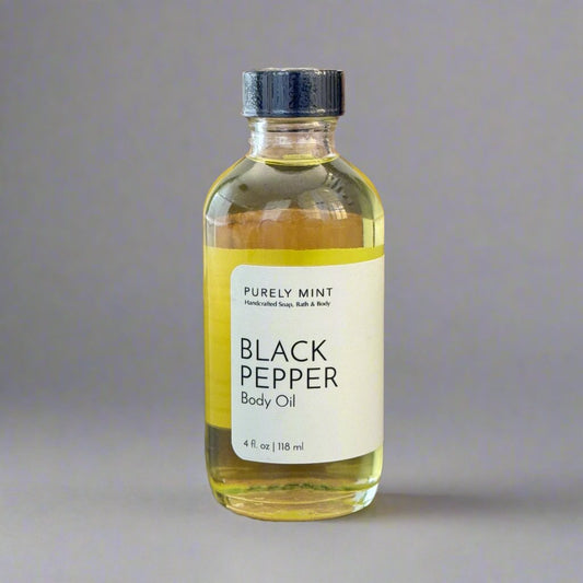 Black Pepper 4 oz Body Oil in clear glass bottle, white label, black top,commercial photography packshot, light gray seamless backdrop, neutral lighting