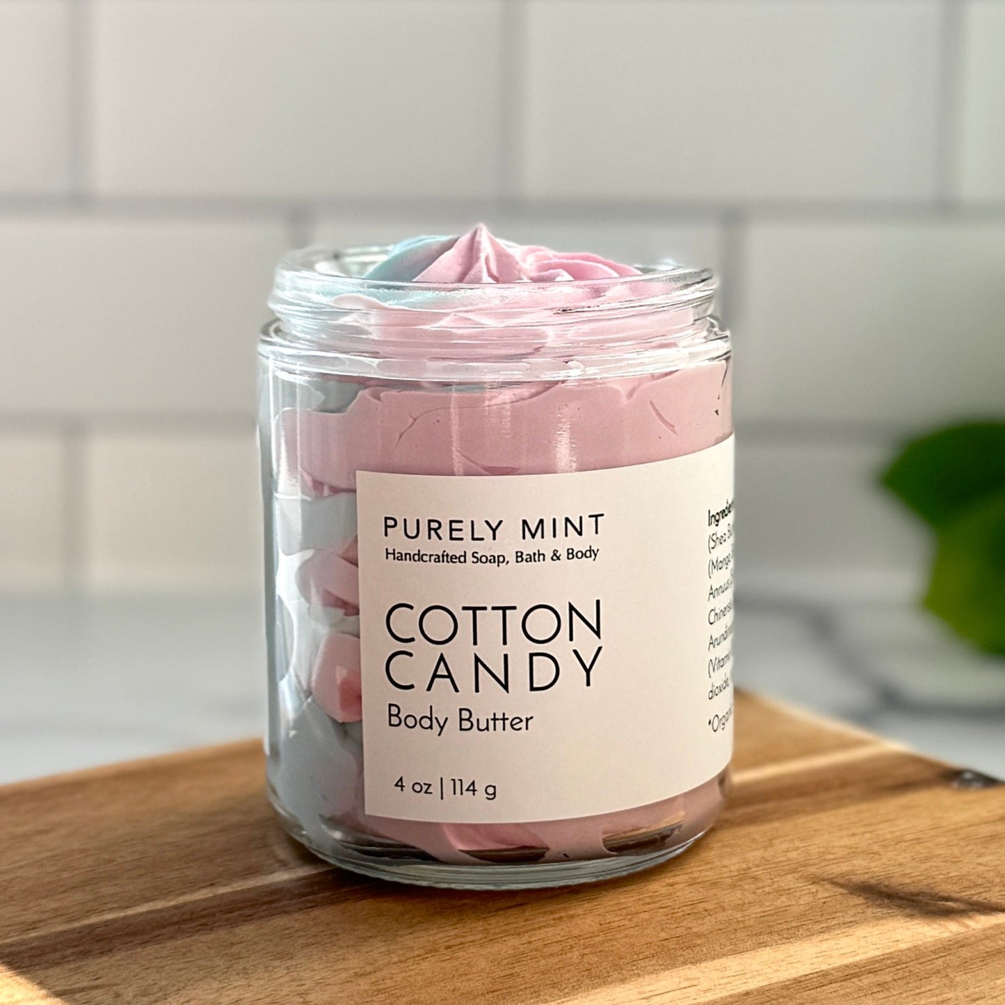 Cotton Candy Pink & Blue body butter clear glass jar white label in a modern bathroom, marble, luxury, spa, plants, commercial advertising photography