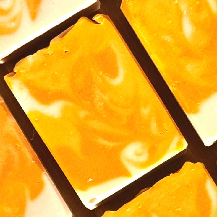 Close-up of orange mango papaya cold process soap in a grid pattern