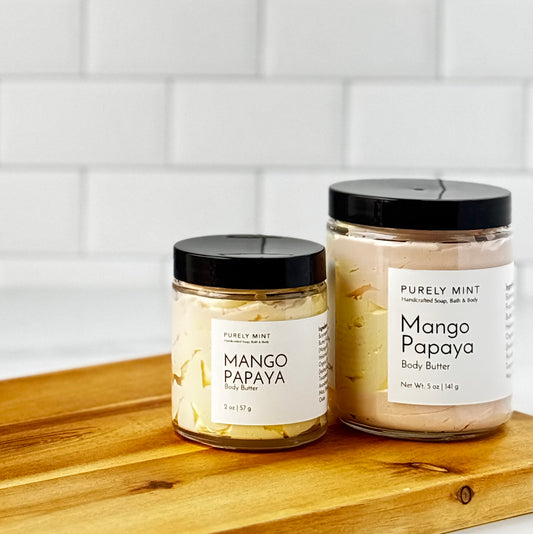 Mango Papaya Body Butter jars on wooden table, featuring Purely Mint's tropical skincare products.