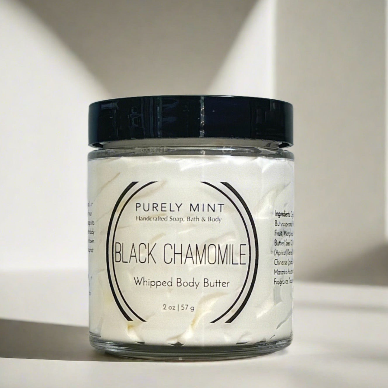small white body butter in glass jar with black lid in a modern bathroom, marble, luxury, spa, plants, commercial advertising photography