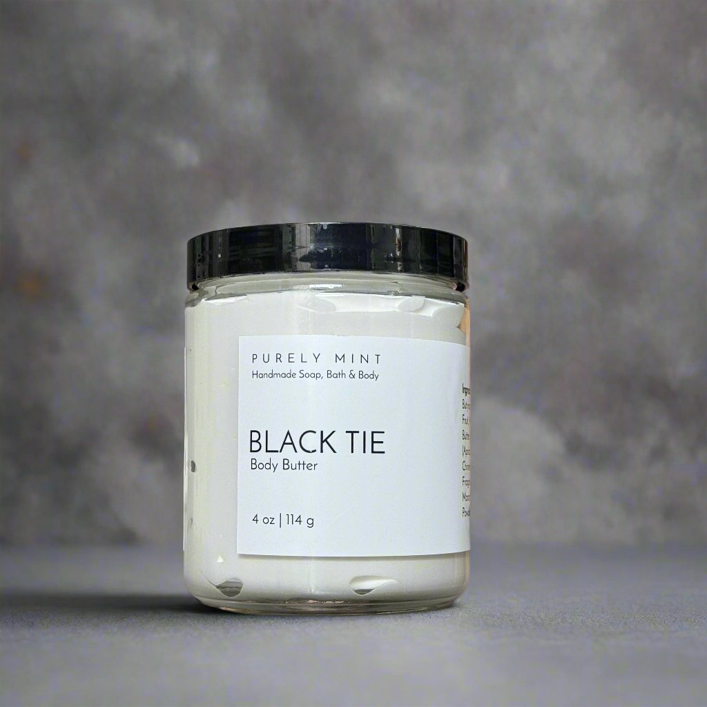 4 oz white body butter, glass jar, white label, black top, commercial photography packshot, charcoal seamless backdrop, neutral lighting