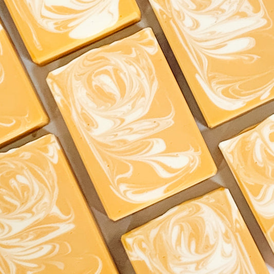 A grid of handmade banana coconut artisan soap bars with a marbled yellow and white pattern, arranged to form a larger image.