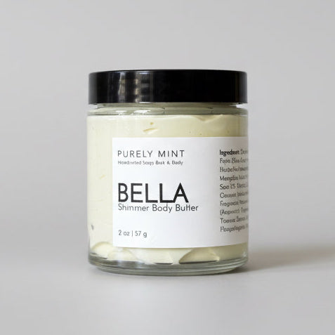 Jar of Bella body butter on a light gray seamless backdrop. 