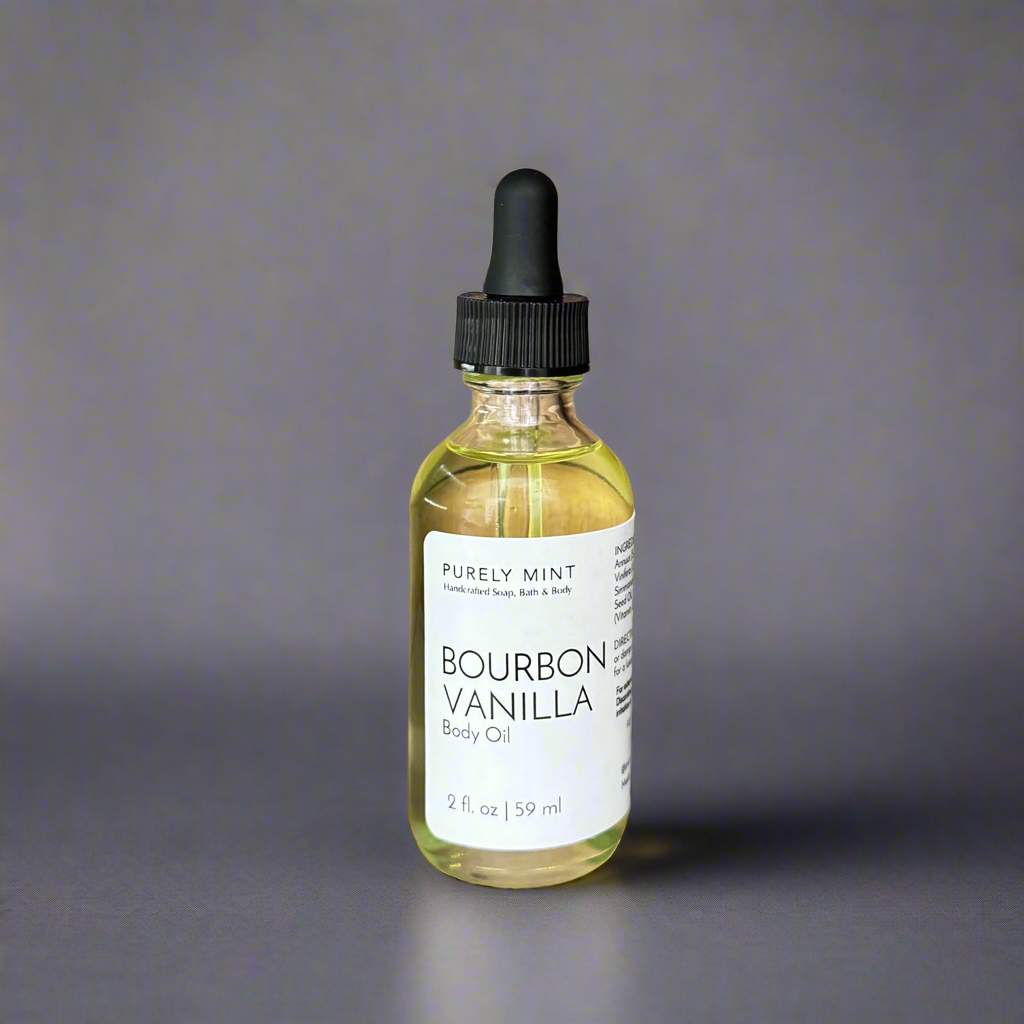 Bourbon Vanilla 2 oz Body Oil in clear glass bottle, white label, black top,commercial photography packshot, light gray seamless backdrop, neutral lighting