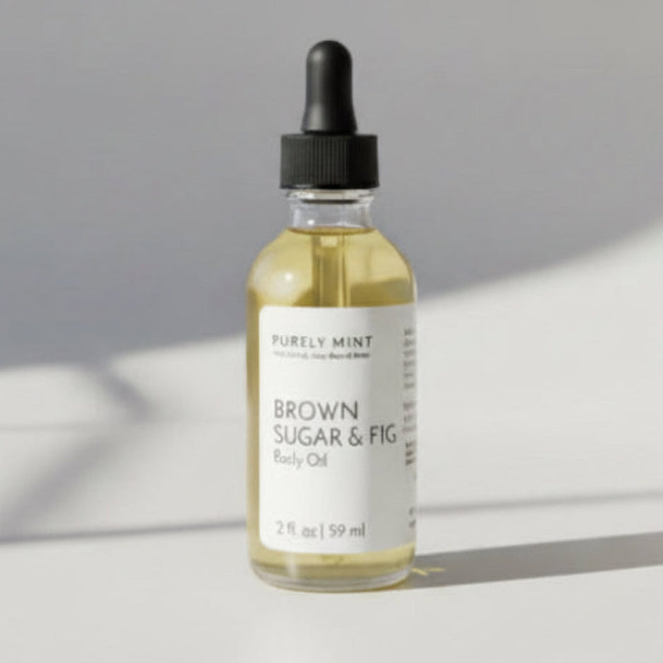 A sleek bottle of Purely Mint Brown Sugar & Fig body oil, featuring a minimalist label, set against a neutral background to highlight its natural aesthetic.