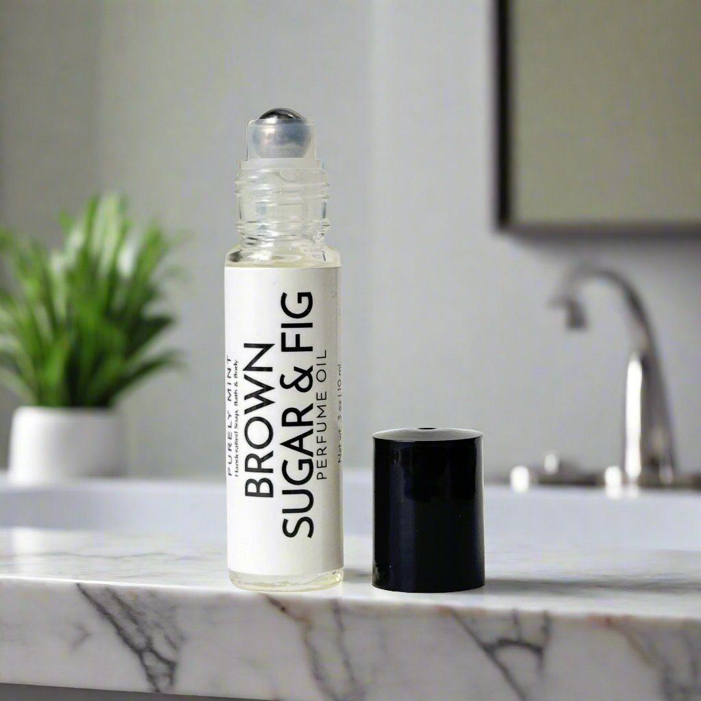 Brown Sugar & Fig Perfume Oil, white label, metal roller ball, black top, in a modern bathroom, counter, white marble counter, green plants in the background, 