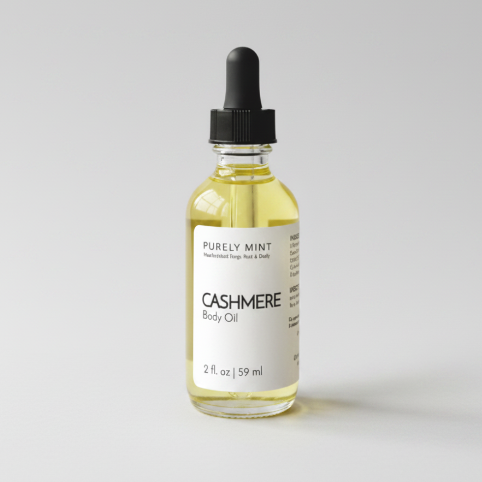 A 2 fl oz glass bottle of Purely Mint Cashmere Body Oil with a black dropper cap, set against a neutral light gray background.