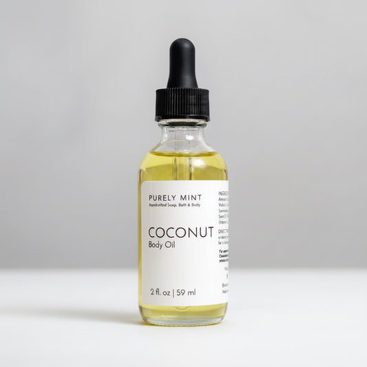 A 2 fl oz glass bottle of Purely Mint Coconut Body Oil with a black dropper cap, set against a neutral light gray background.