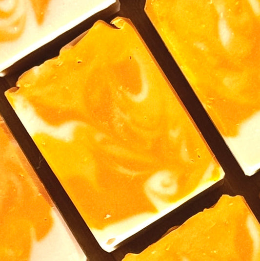 Close-up of orange mango papaya cold process soap in a grid pattern