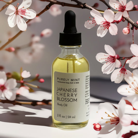2 oz bottle of Japanese Cherry Blossom body oil surrounded by Japanese cherry blossom tree branches.