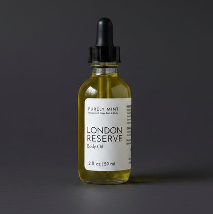 Bottle of London Reserve body oil with a dropper on a dark gray background
