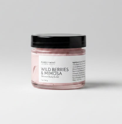 Small jar of wild berries & mimosa body butter, white label with black top on a light grey backdrop.