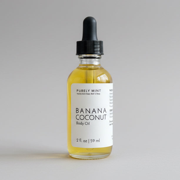 Bottle of Banana Coconut Body Oil on a commercial photography packshot, light gray seamless backdrop, neutral lighting.