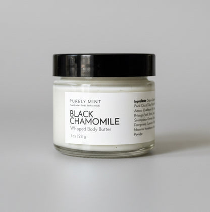 Bottle of Black Chamomile oil on a light gray seamless backdrop.