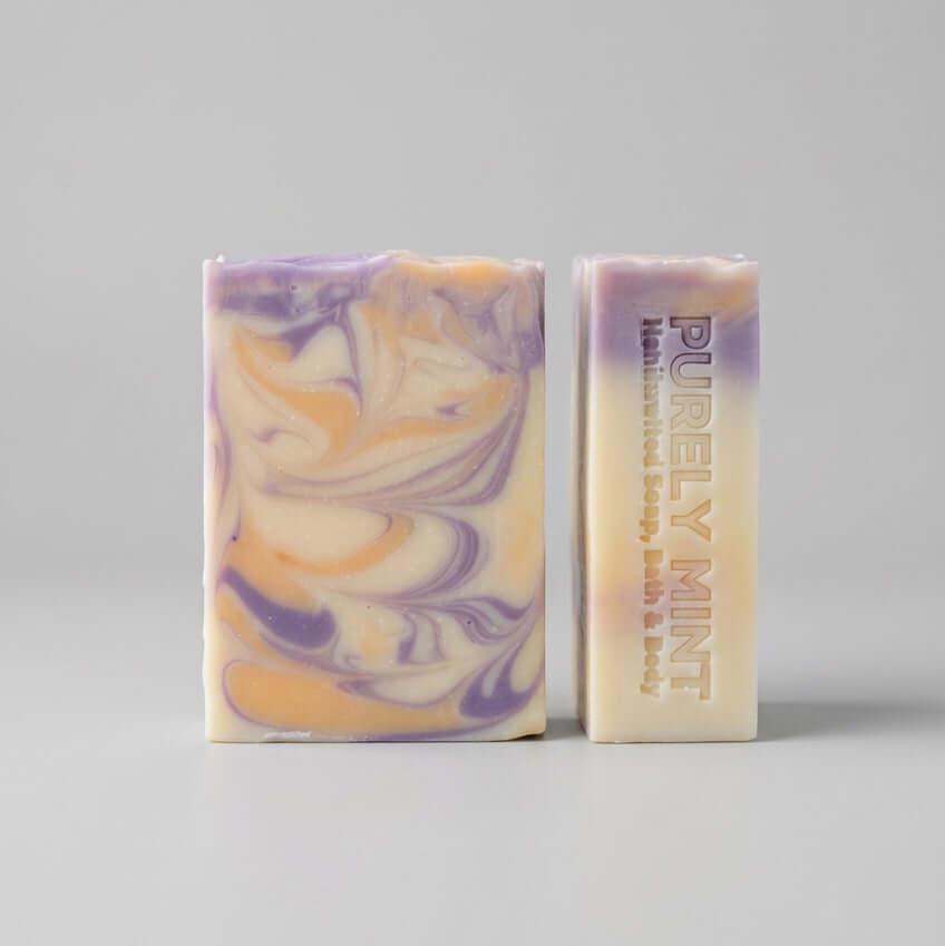 yellow and purple lemon lavender artisan soap on a light gray surface.