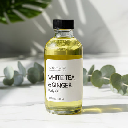 Bottle of White Tea & Ginger body oil in 4 oz on a marble surface with a gray background in a modern bathroom, marble, luxury, spa, plants, commercial advertising photography