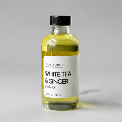 Bottle of White Tea & Ginger body oil on a commercial photography packshot, light gray seamless backdrop, neutral lighting